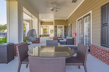 A patio with a table and chairs and a ceiling fan